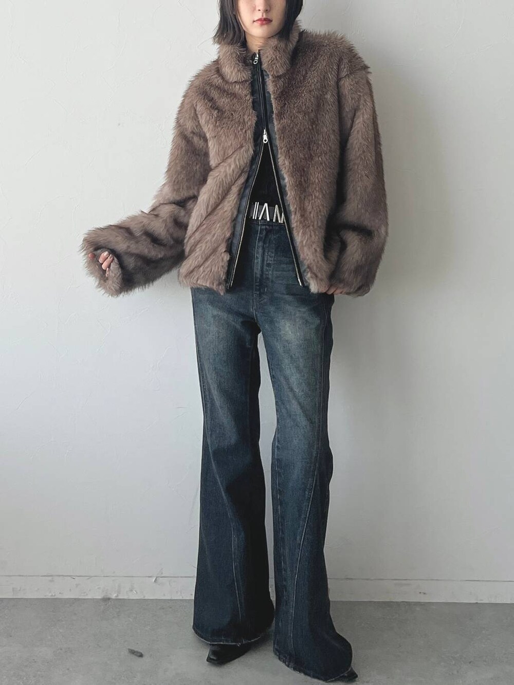 ブルー系のデニムパンツ、ブラック系のパンプスを着用したレディースの秋コーディネートの2枚目の写真