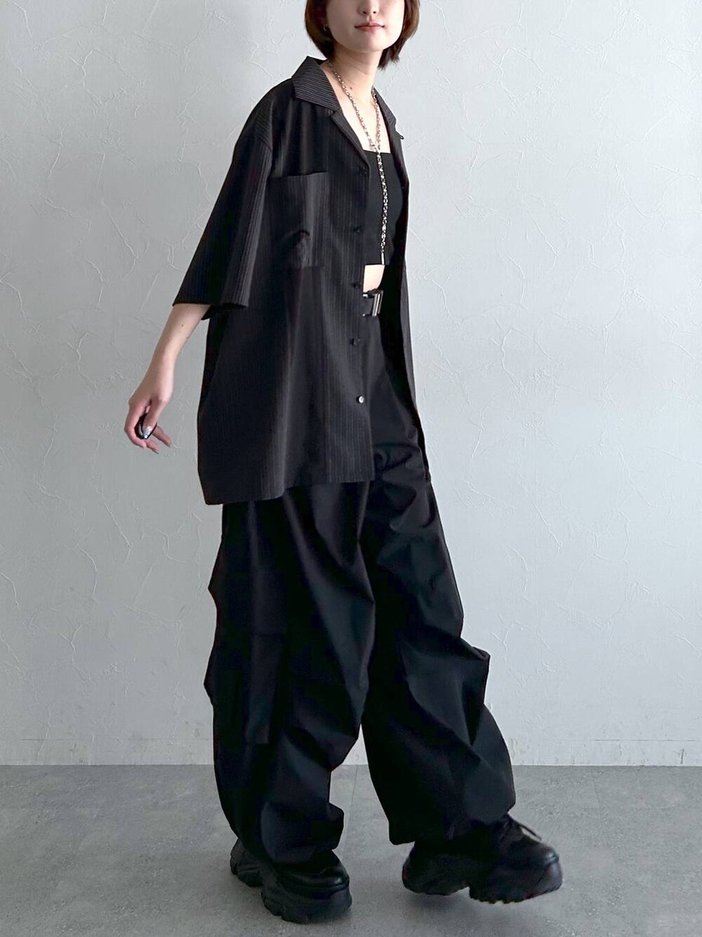 ブラック系のシャツ/ブラウス、ブラック系のカーゴパンツ、ブラック系のベルトを着用したレディースの春コーディネートの5枚目の写真