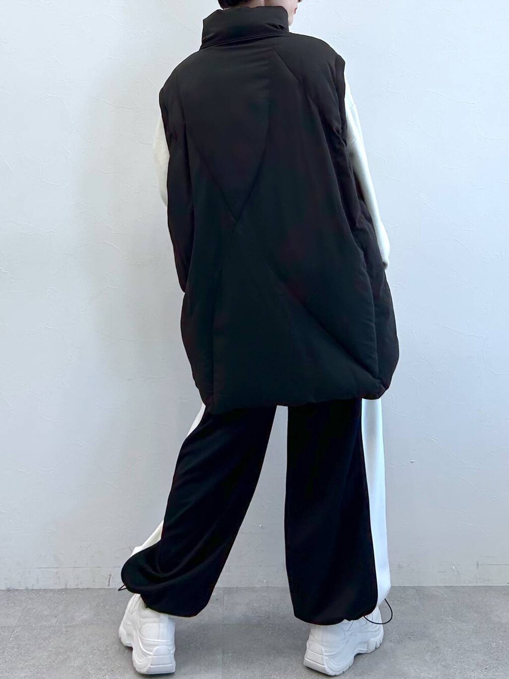 ブラック系のブルゾン、ブラック系のその他パンツ、ホワイト系のニット/セーターを着用したレディースの秋コーディネートの8枚目の写真