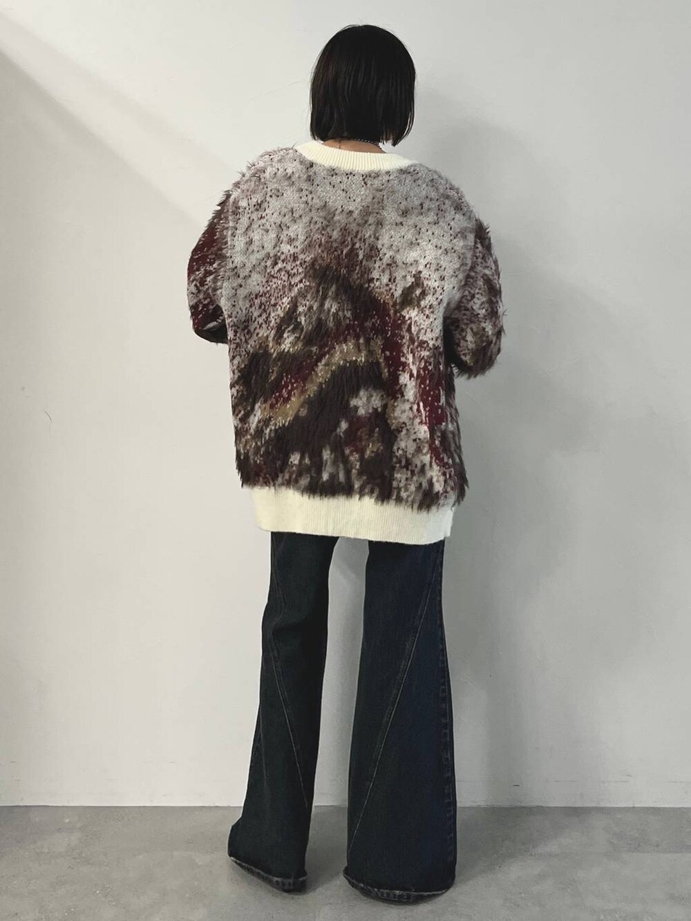 ブルー系のデニムパンツ、ブラック系のパンプス、ホワイト系のカーディガン/ボレロを着用したレディースの秋コーディネートの8枚目の写真