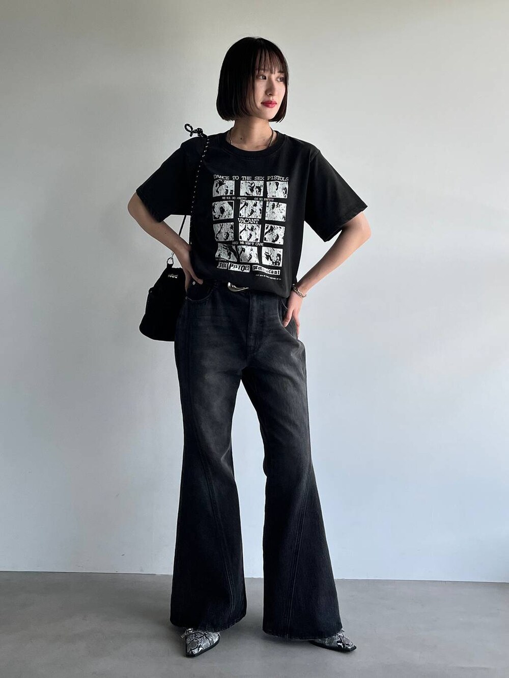 ブラック系のデニムパンツ、ホワイト系のパンプス、ブラック系のTシャツ/カットソーを着用したレディースの夏コーディネートの2枚目の写真