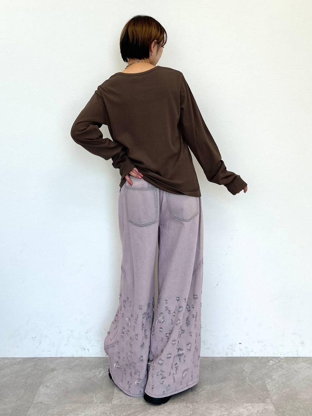 ピンク系のデニムパンツ、ブラウン系のTシャツ/カットソー、シルバー系のネックレスを着用したレディースの秋コーディネートの6枚目の写真