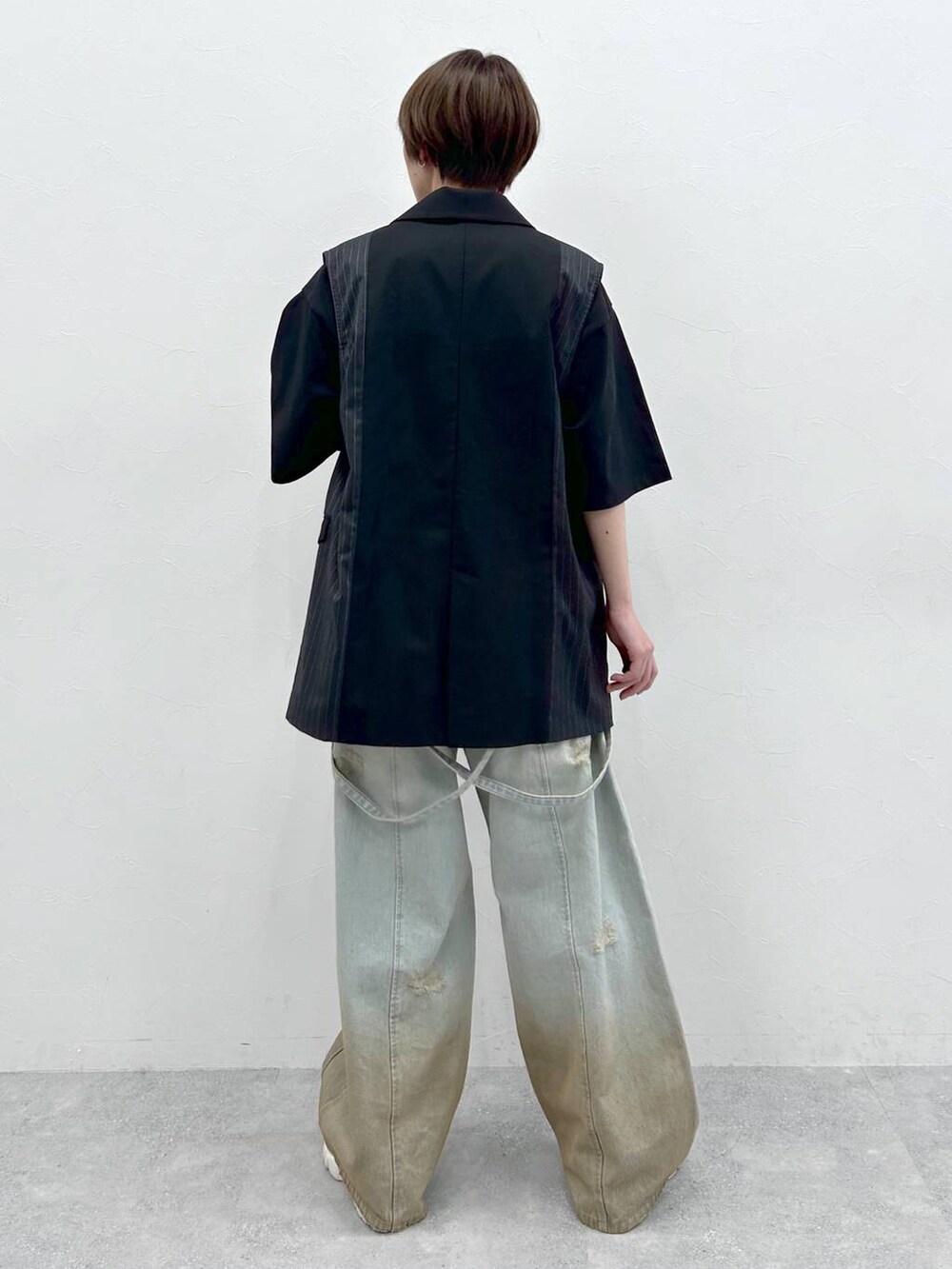 ブラック系のTシャツ/カットソー、ブルー系のデニムパンツ、ブラック系のテーラードジャケットを着用したレディースの春コーディネートの3枚目の写真