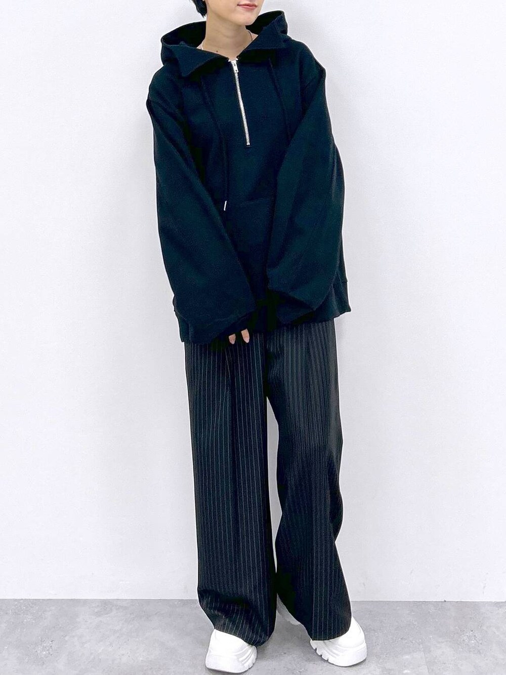 ブラック系のスラックス、ブラック系のパーカーを着用したレディースの秋コーディネートの2枚目の写真