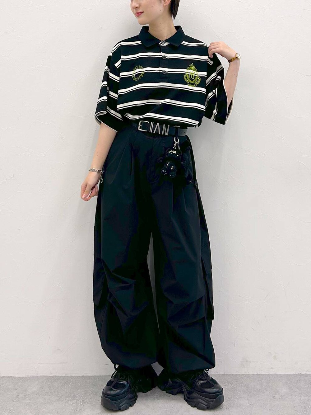 ブラック系のスニーカー、ブラック系のカーゴパンツ、ブラック系のTシャツ/カットソーを着用したレディースの夏コーディネートの3枚目の写真