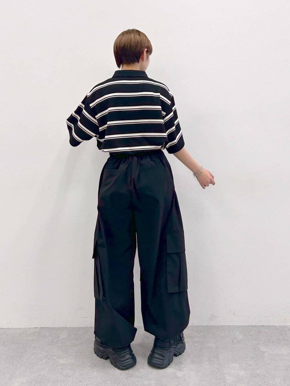 ブラック系のスニーカー、ブラック系のカーゴパンツ、ブラック系のTシャツ/カットソーを着用したレディースの夏コーディネートの6枚目の写真