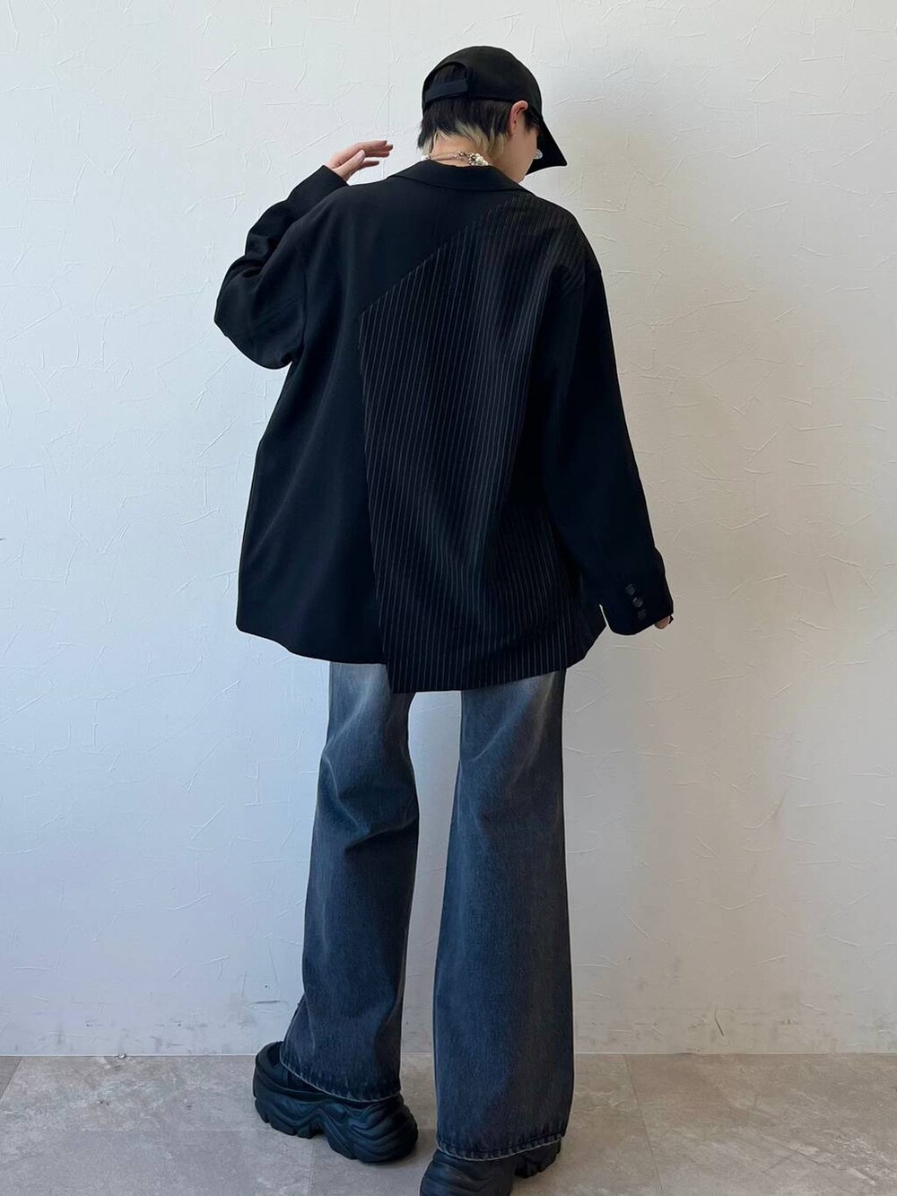 ブラック系のスニーカー、ブラック系のキャミソール、ブラック系のテーラードジャケットを着用したレディースの春コーディネートの7枚目の写真