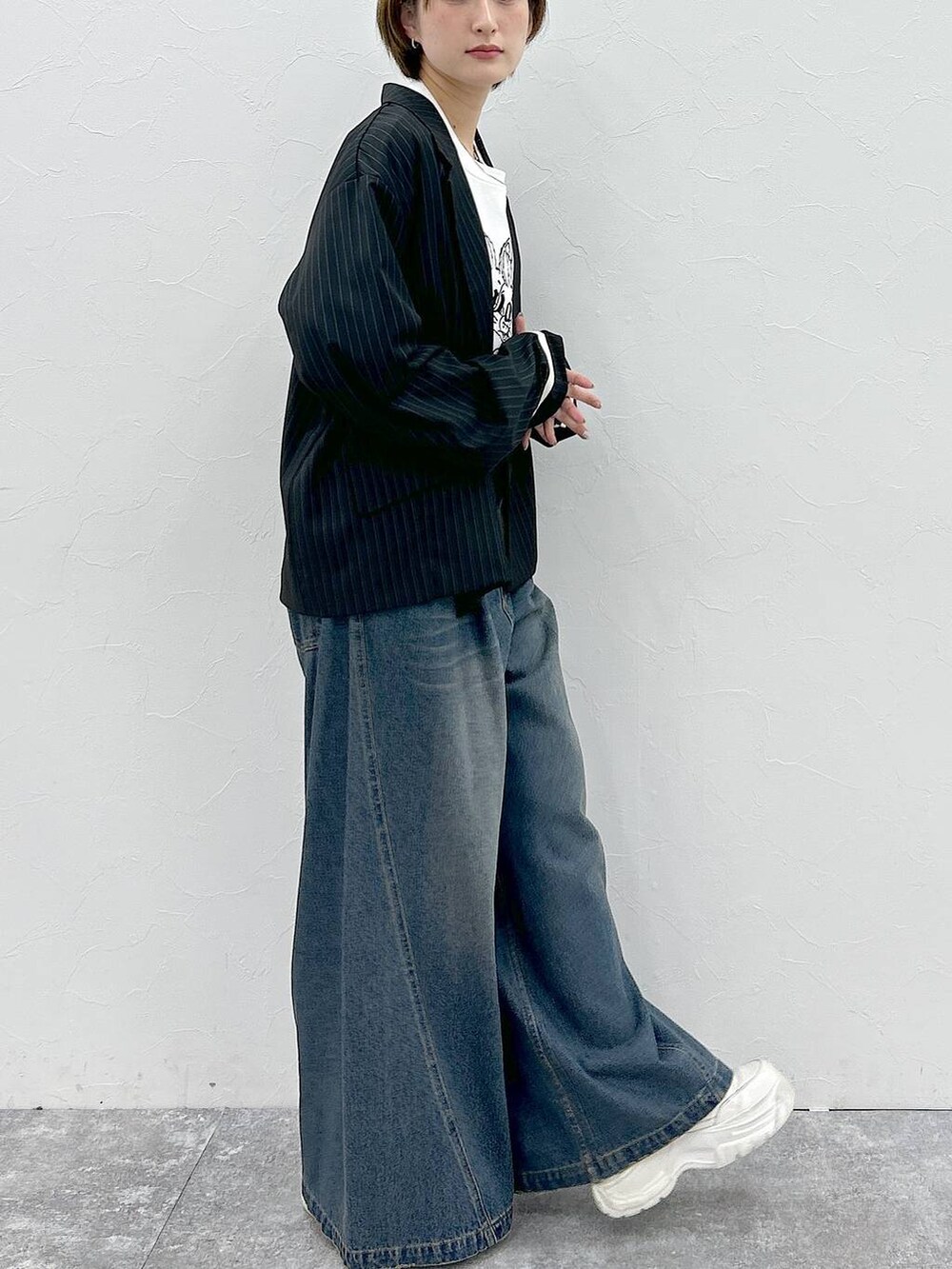 ブルー系のデニムパンツ、ホワイト系のTシャツ/カットソー、ブラック系のテーラードジャケットを着用したレディースの春コーディネートの6枚目の写真