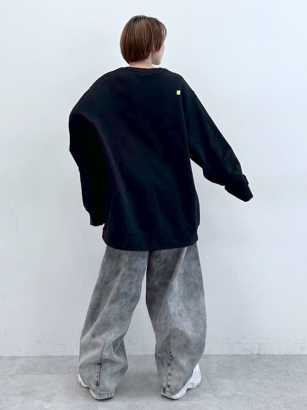 ブラック系のデニムパンツ、ブラック系のスウェット、シルバー系のネックレスを着用したレディースの夏コーディネートの6枚目の写真