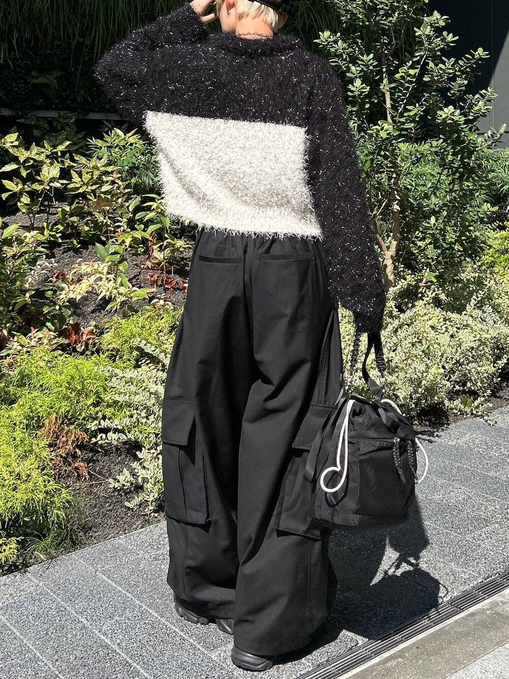 ブラック系のショルダーバッグ、ブラック系のスニーカー、ホワイト系のニット/セーターを着用したレディースの秋コーディネートの8枚目の写真