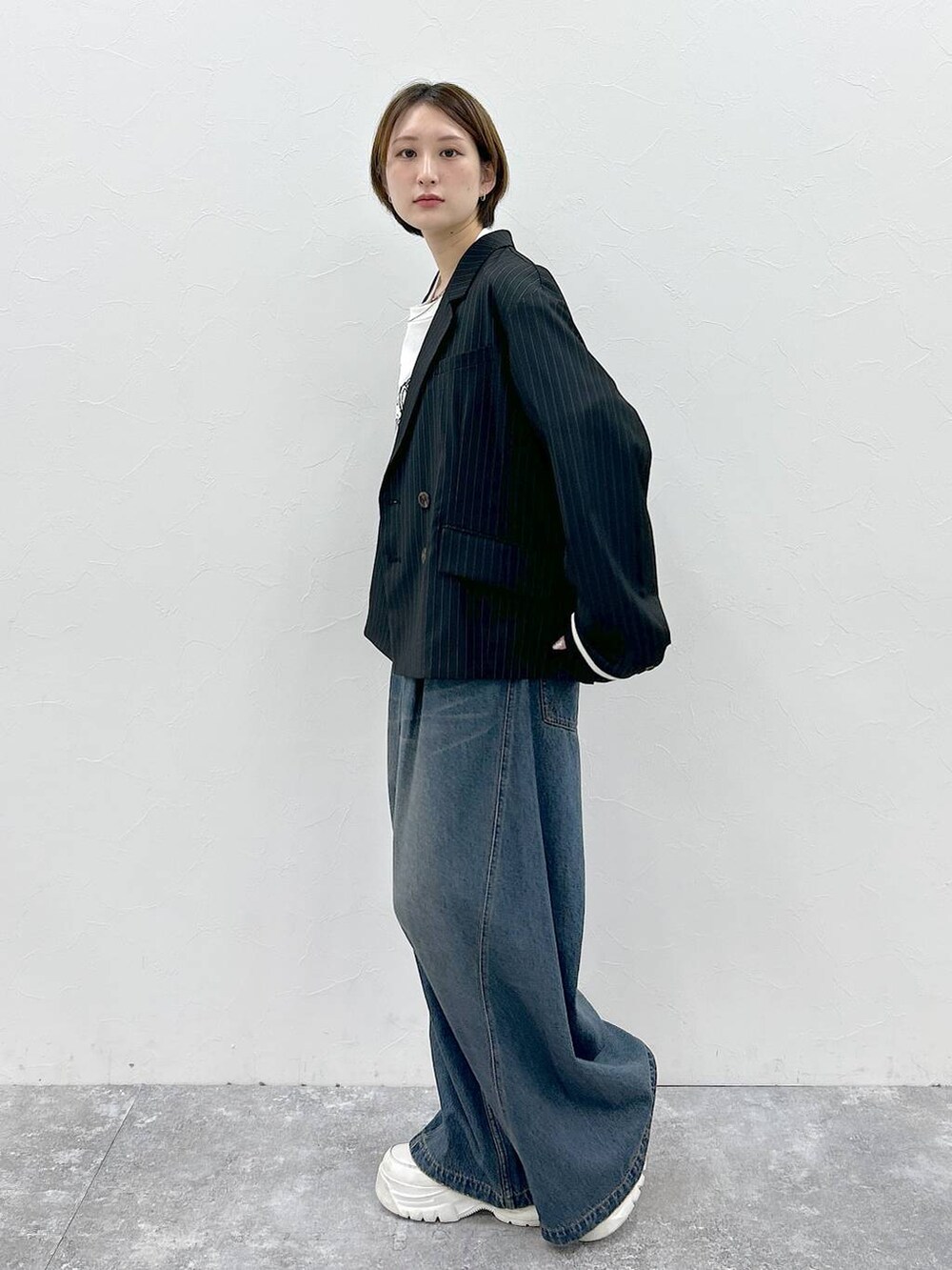 ブルー系のデニムパンツ、ホワイト系のTシャツ/カットソー、ブラック系のテーラードジャケットを着用したレディースの春コーディネートの3枚目の写真