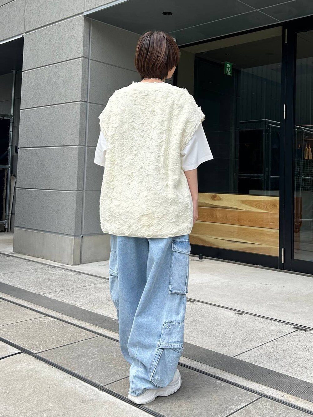 ホワイト系のベスト、ホワイト系のTシャツ/カットソー、ブルー系のデニムパンツを着用したレディースの夏コーディネートの7枚目の写真