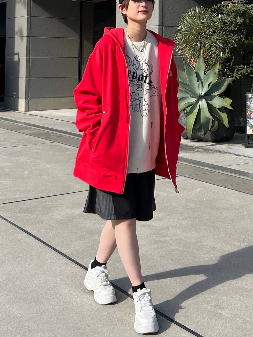 レッド系のパーカー、ホワイト系のニット/セーター、ブラック系のスラックスを着用したレディースの冬コーディネートの3枚目の写真