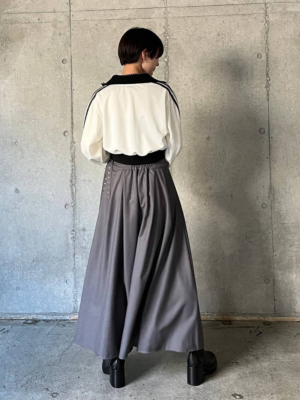 ブラック系のキャミソール、ブラック系のブーツ、グレー系のスカートを着用したレディースの冬コーディネートの4枚目の写真