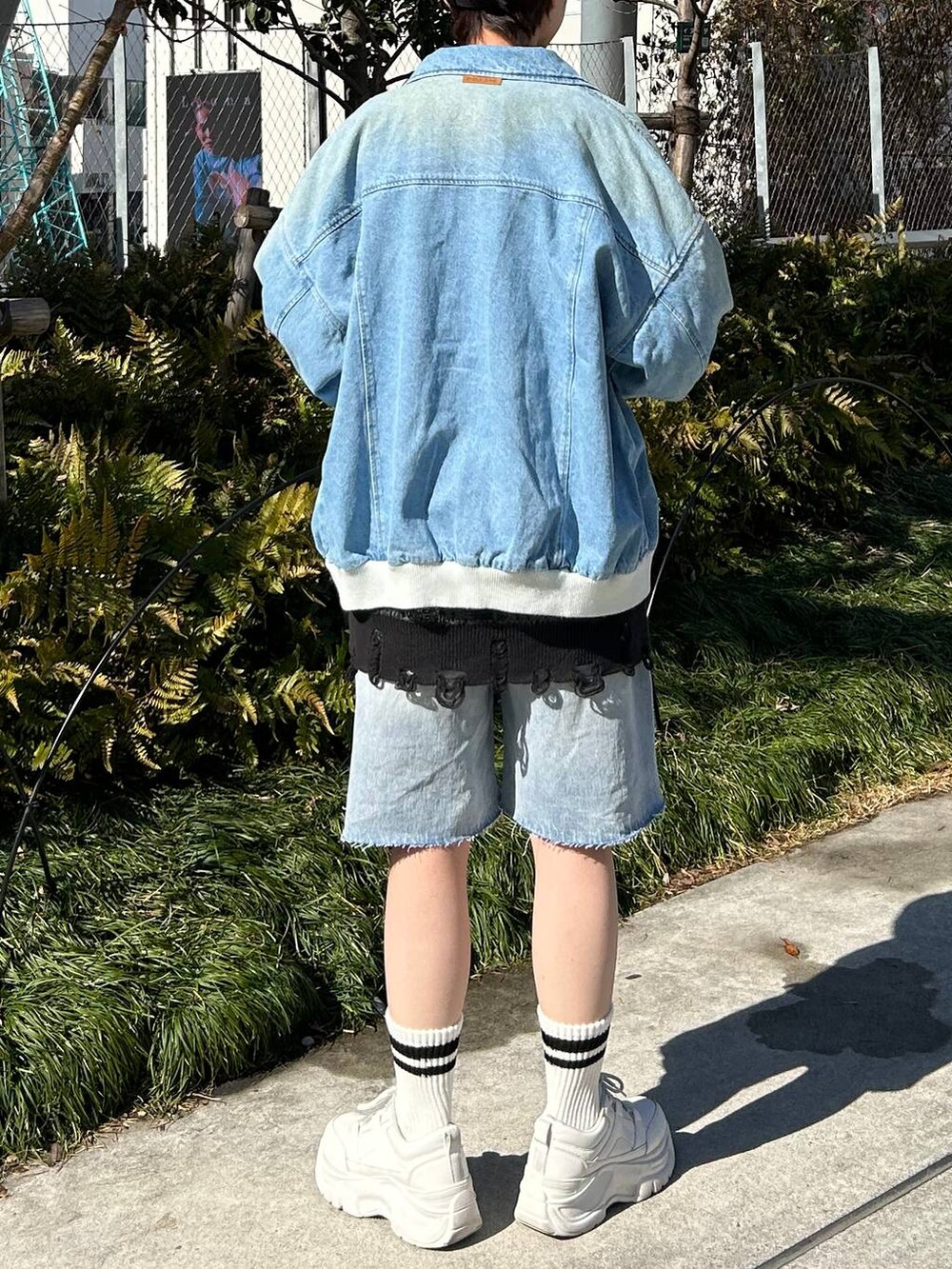 ブルー系のデニムジャケット、ブルー系のデニムパンツ、ブラック系のカーディガン/ボレロを着用したレディースの春コーディネートの7枚目の写真