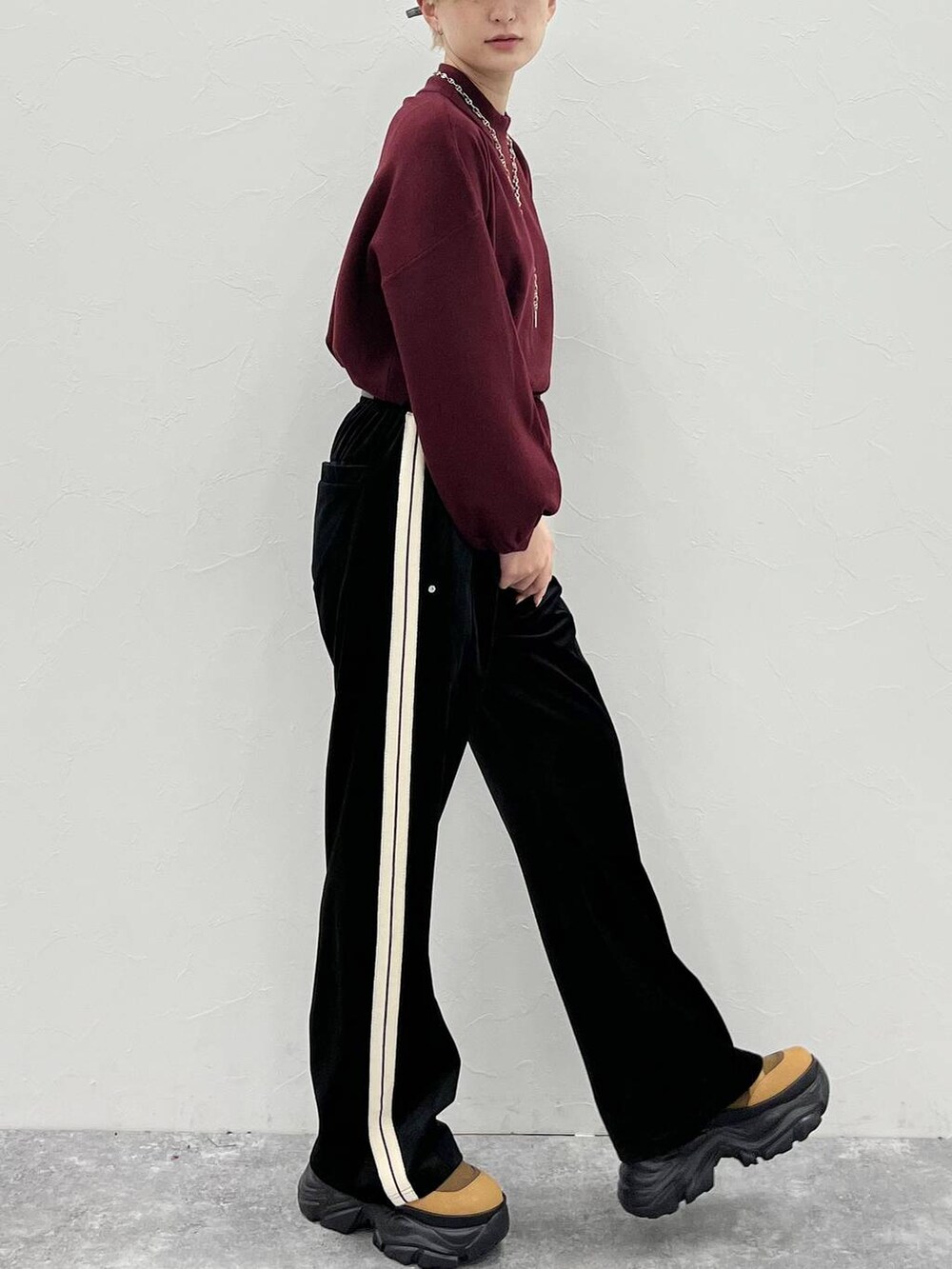 ブラウン系のブーツ、レッド系のニット/セーター、ブラック系のスウェットパンツを着用したレディースの秋コーディネートの6枚目の写真