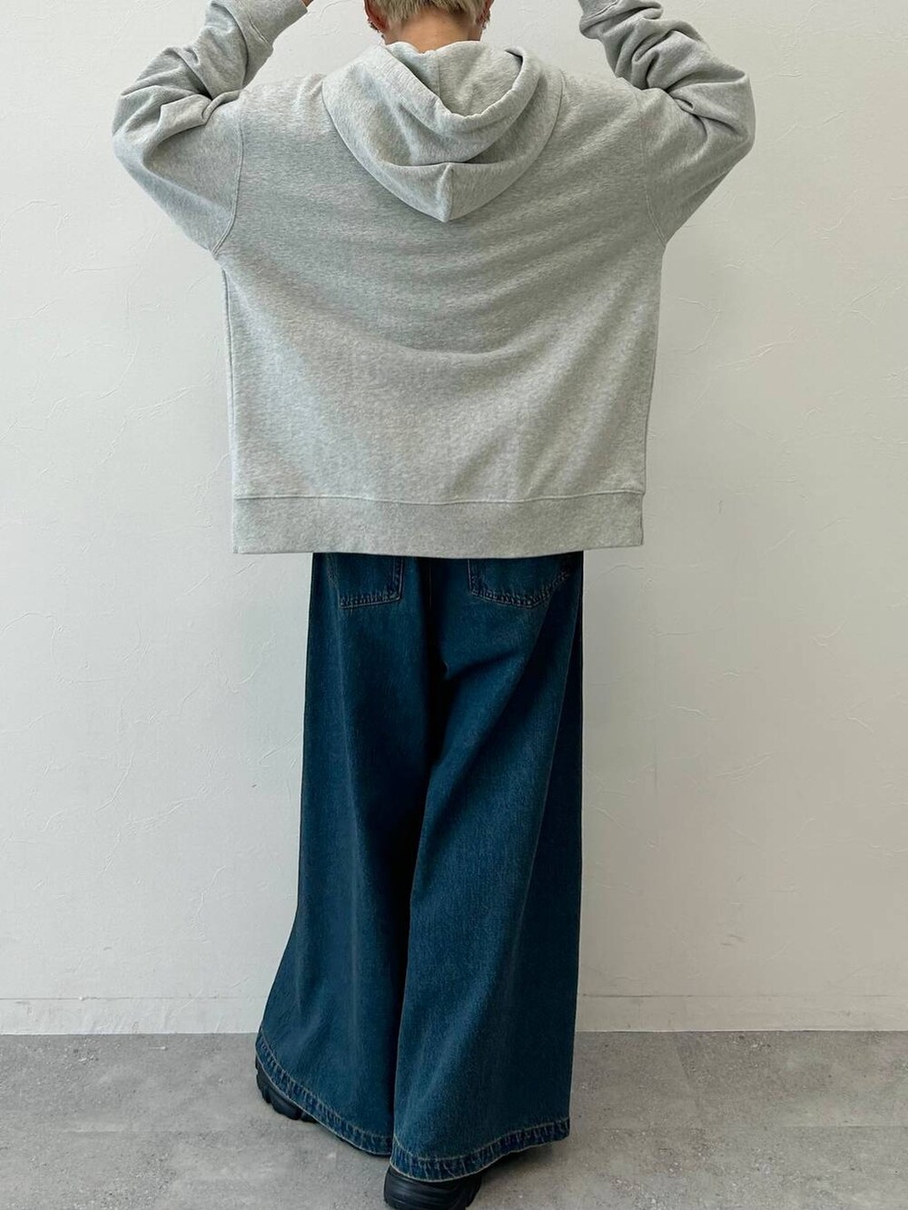 ブルー系のデニムパンツ、ブラック系のブーツ、グレー系のパーカーを着用したレディースの秋コーディネートの8枚目の写真