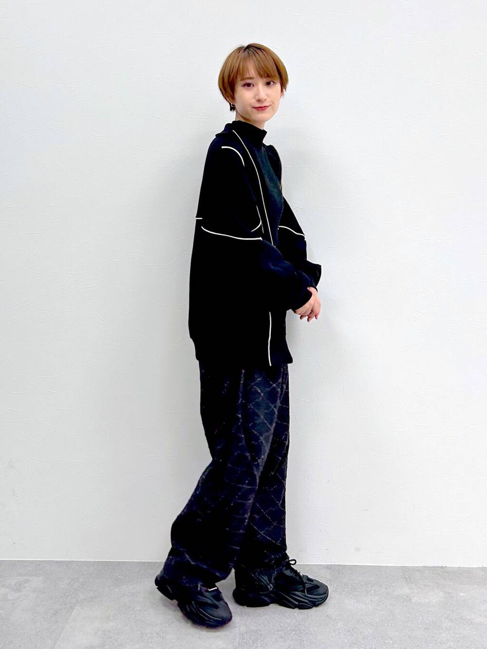 ブラック系のスウェット、ブラック系のデニムパンツ、ブラック系のベルトを着用したレディースの冬コーディネートの6枚目の写真