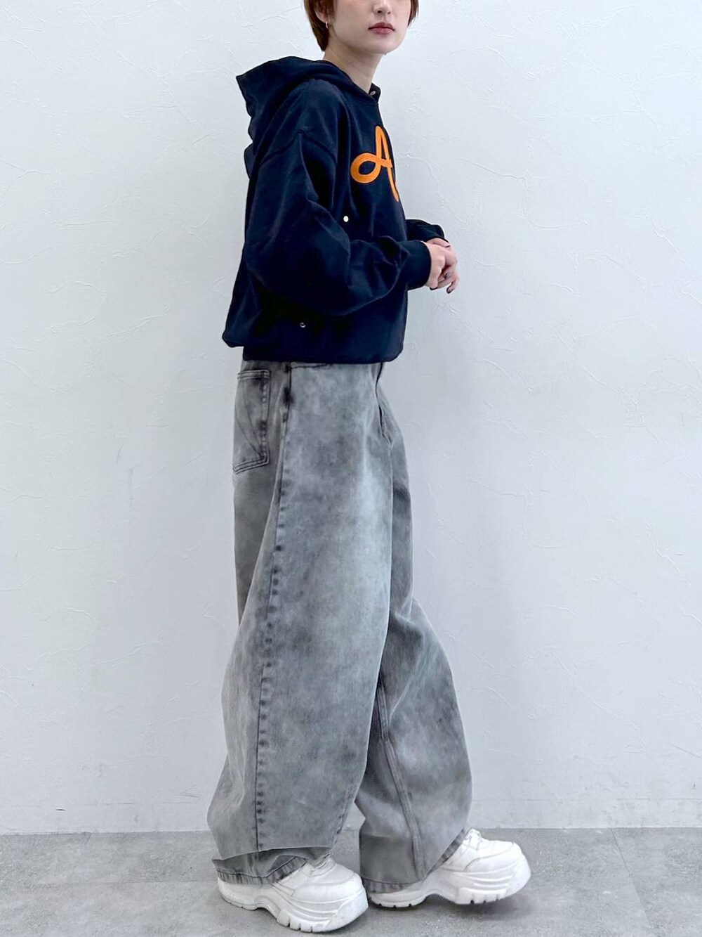 ブルー系のパーカー、ブラック系のデニムパンツを着用したレディースの春コーディネートの7枚目の写真