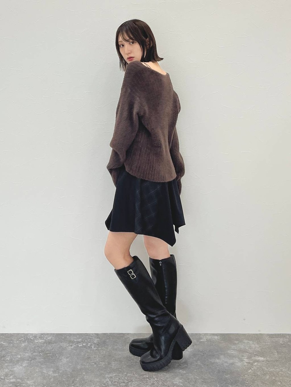 ブラック系のスカート、ブラウン系のニット/セーターを着用したレディースの秋コーディネートの5枚目の写真