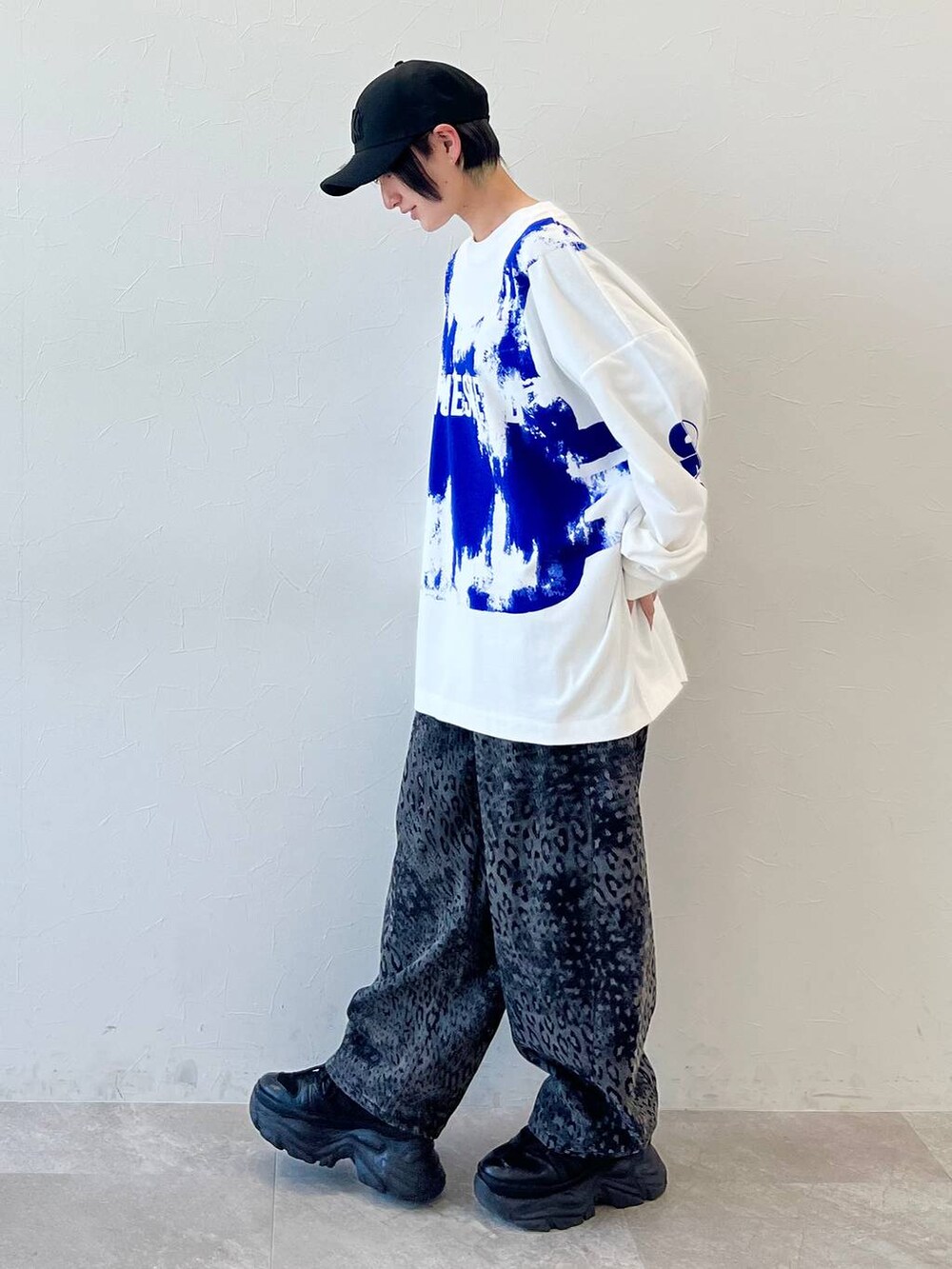 ブラック系のスニーカー、ブラック系のデニムパンツ、ブラック系のキャップを着用したレディースの春コーディネートの4枚目の写真