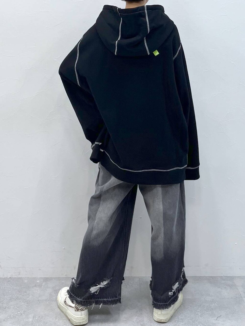 ブラック系のデニムパンツ、ブラック系のパーカーを着用したレディースの秋コーディネートの7枚目の写真