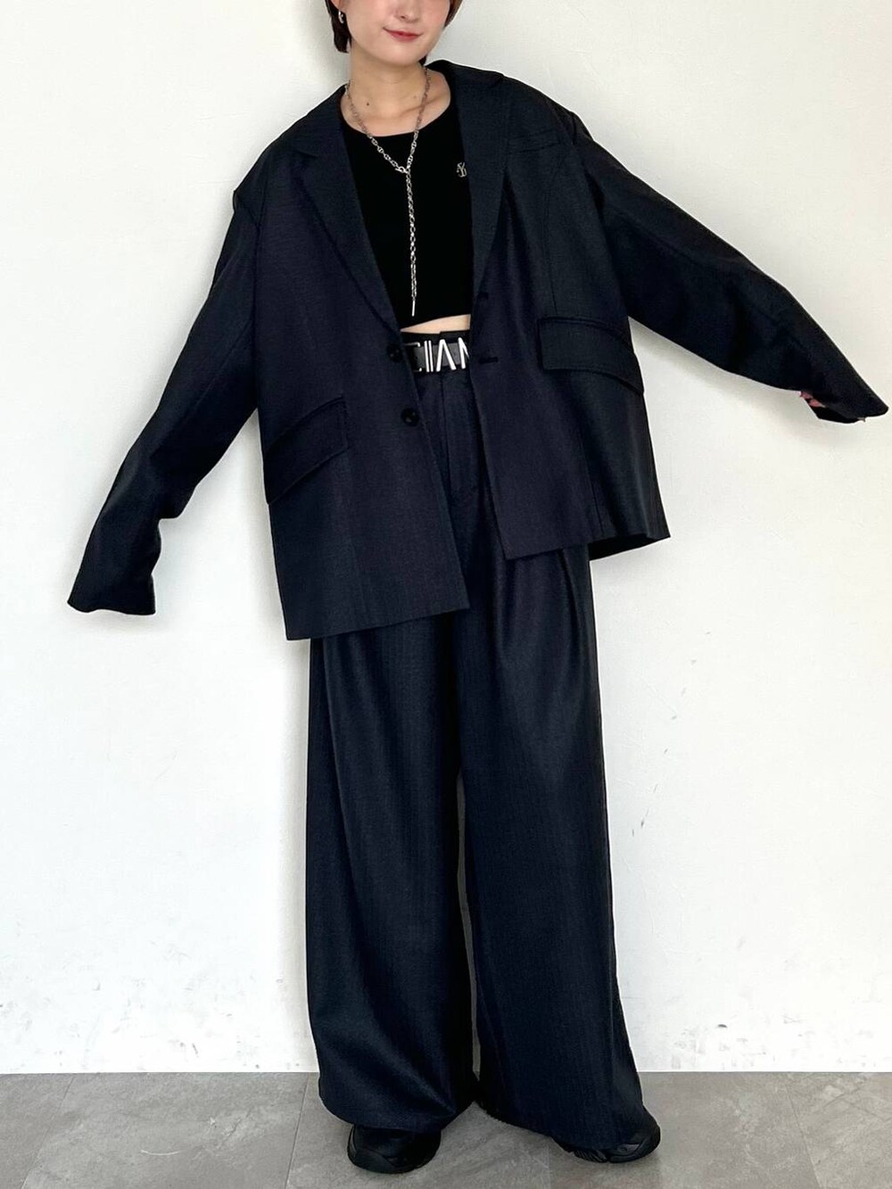 ブラック系のスラックス、ブラック系のテーラードジャケット、ブラック系のベルトを着用したレディースの秋コーディネートの2枚目の写真