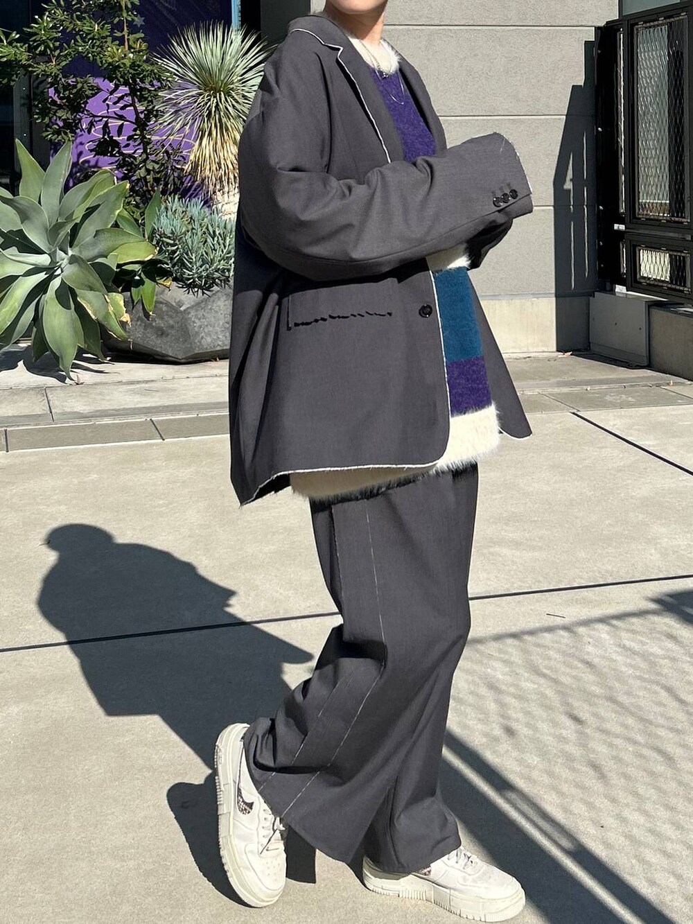 グレー系のスラックス、グレー系のテーラードジャケット、ブルー系のニット/セーターを着用したレディースの冬コーディネートの9枚目の写真