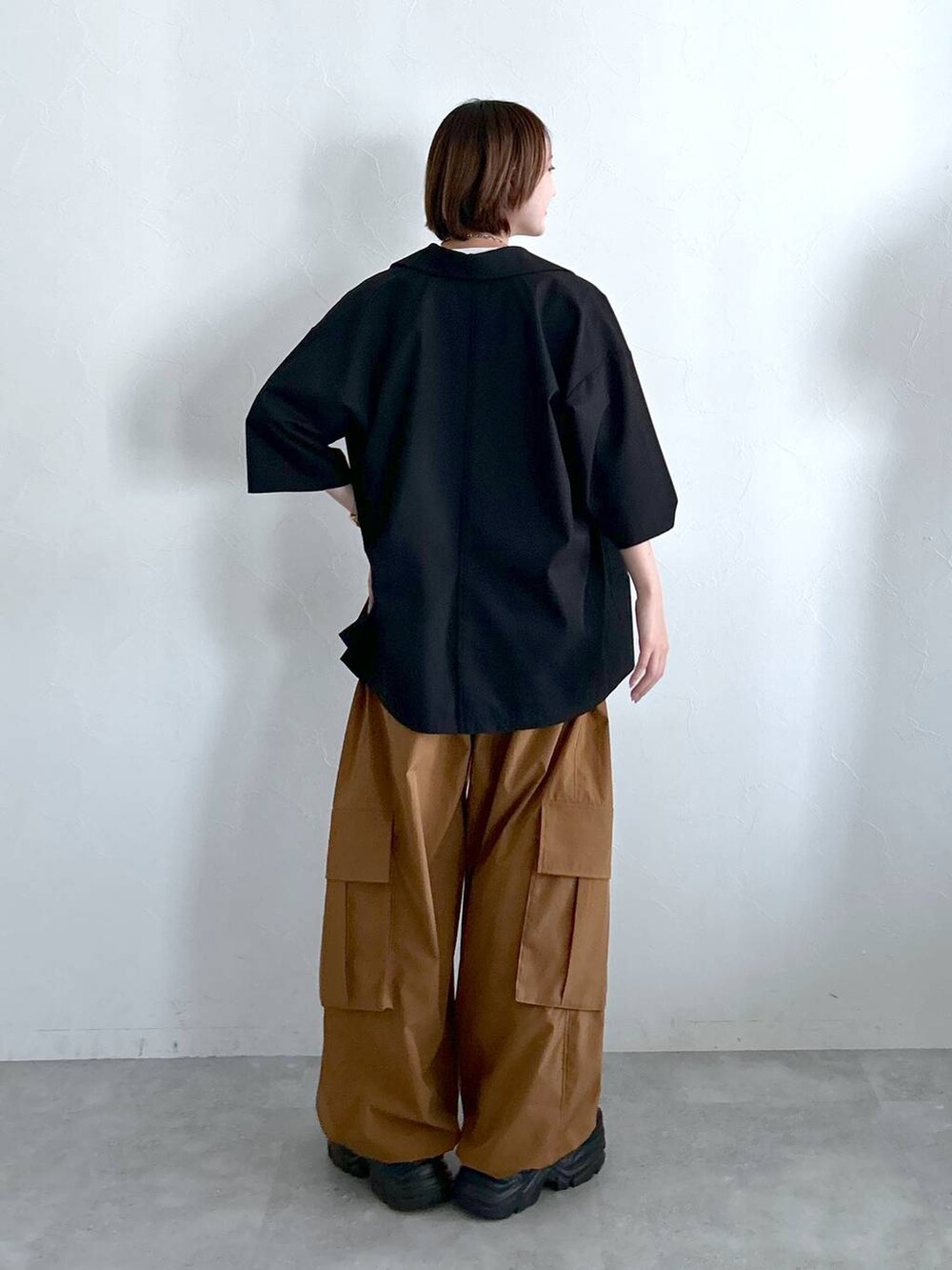 ブラック系のテーラードジャケット、ブラウン系のカーゴパンツ、ホワイト系のTシャツ/カットソーを着用したレディースの春コーディネートの7枚目の写真