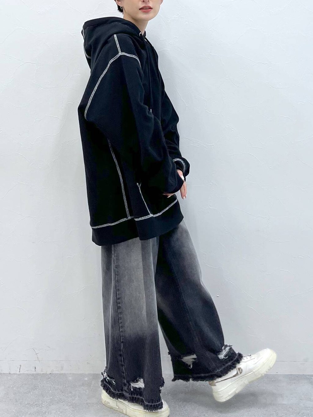 ブラック系のデニムパンツ、ブラック系のパーカーを着用したレディースの秋コーディネートの5枚目の写真