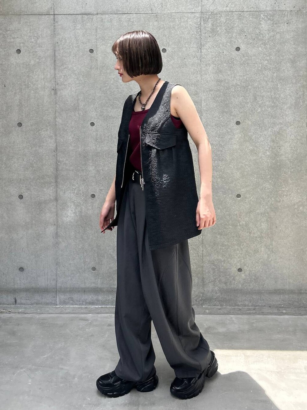 ブラック系のスニーカー、ブラック系のベスト、グレー系のその他パンツを着用したレディースの夏コーディネートの2枚目の写真