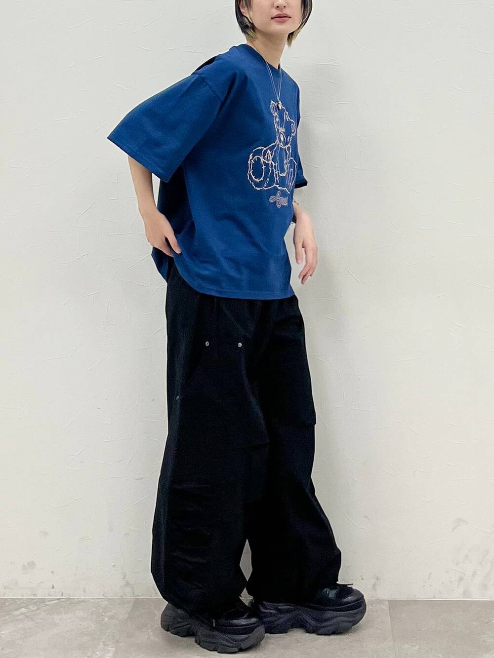 ブラック系のスニーカー、ブルー系のTシャツ/カットソー、ブラック系のカーゴパンツを着用したレディースの春コーディネートの5枚目の写真