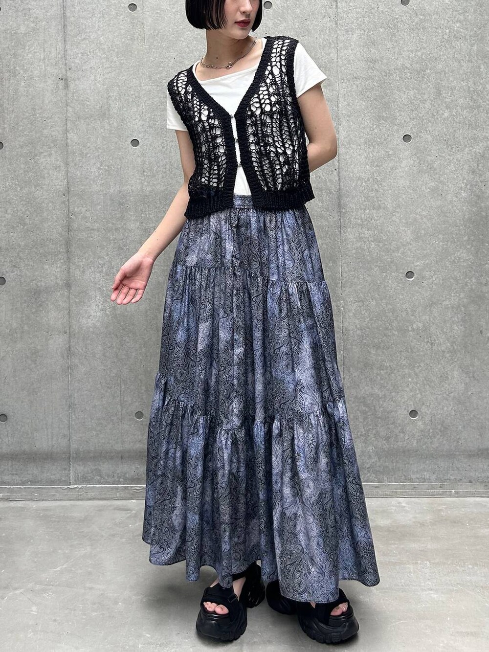 ブラック系のサンダル、ホワイト系のTシャツ/カットソー、ブラック系のスカートを着用したレディースの夏コーディネートの2枚目の写真