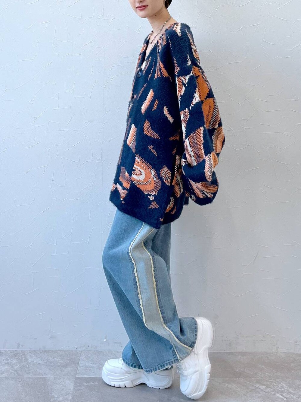 ブルー系のデニムパンツ、ブルー系のニット/セーター、ブラック系のニットキャップ/ビーニーを着用したレディースの秋コーディネートの3枚目の写真