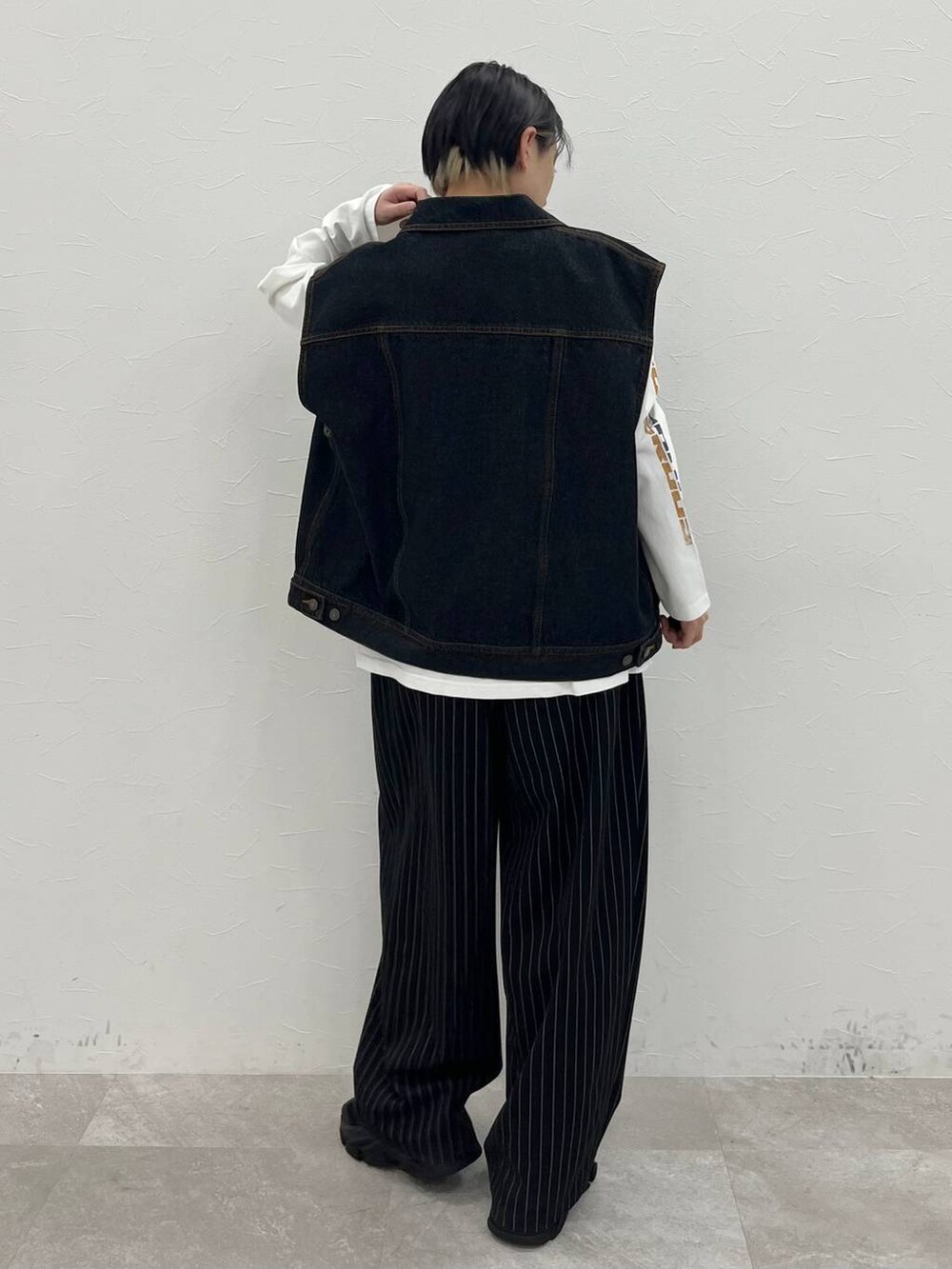 ホワイト系のTシャツ/カットソー、ブラック系のスラックス、ブラック系のデニムジャケットを着用したレディースの春コーディネートの5枚目の写真