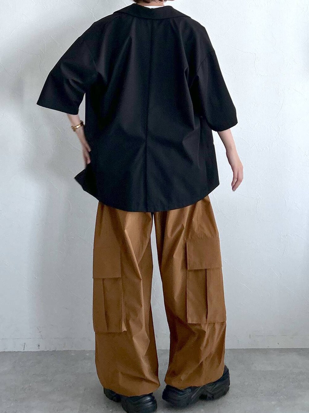 ブラック系のテーラードジャケット、ブラウン系のカーゴパンツ、ホワイト系のTシャツ/カットソーを着用したレディースの春コーディネートの8枚目の写真