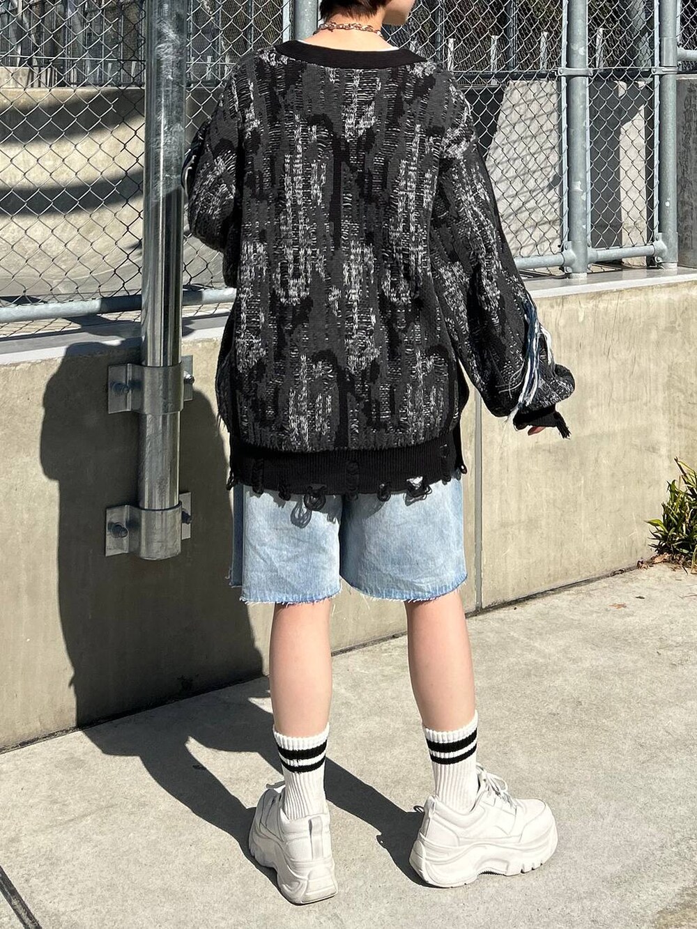 ホワイト系のTシャツ/カットソー、ブラック系のカーディガン/ボレロ、ブルー系のデニムパンツを着用したレディースの春コーディネートの7枚目の写真