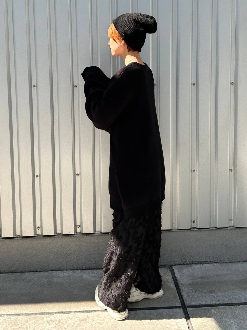 ブラック系のニット/セーター、ブラック系のスラックス、ブラック系のニットキャップ/ビーニーを着用したレディースの冬コーディネートの6枚目の写真