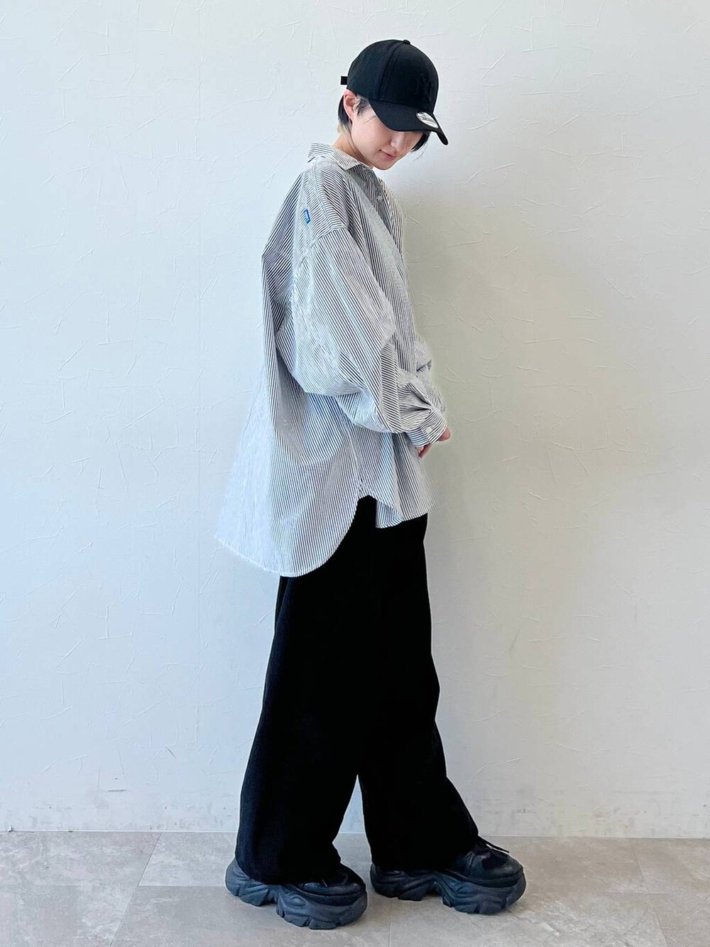 ブラック系のスニーカー、ブラック系のチノパンツ、ブラック系のキャップを着用したレディースの春コーディネートの5枚目の写真