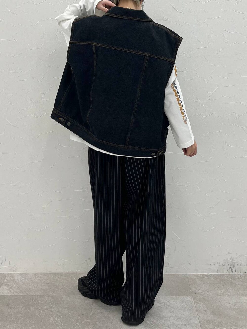 ホワイト系のTシャツ/カットソー、ブラック系のスラックス、ブラック系のデニムジャケットを着用したレディースの春コーディネートの6枚目の写真