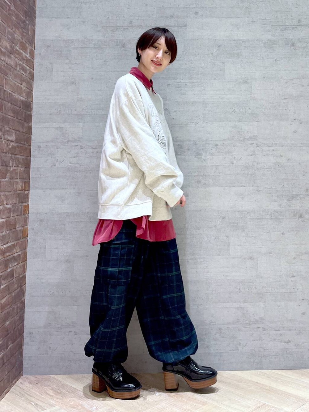 ベージュ系のスウェット、レッド系のシャツ/ブラウス、ブルー系のカーゴパンツを着用したレディースの冬コーディネートの3枚目の写真