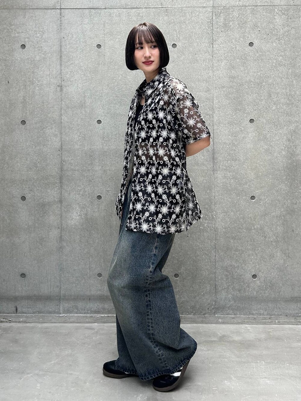 ブルー系のデニムパンツ、ブラック系のスニーカー、ブラック系のキャミソールを着用したレディースの夏コーディネートの2枚目の写真