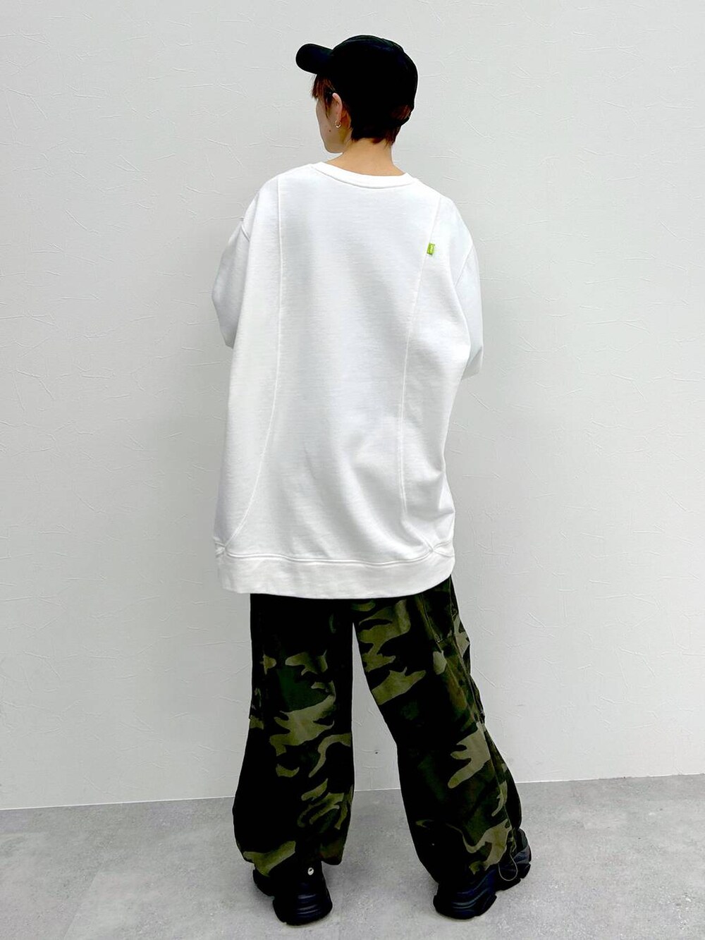 グリーン系のその他パンツ、ホワイト系のスウェット、ブラック系のキャップを着用したレディースの冬コーディネートの7枚目の写真