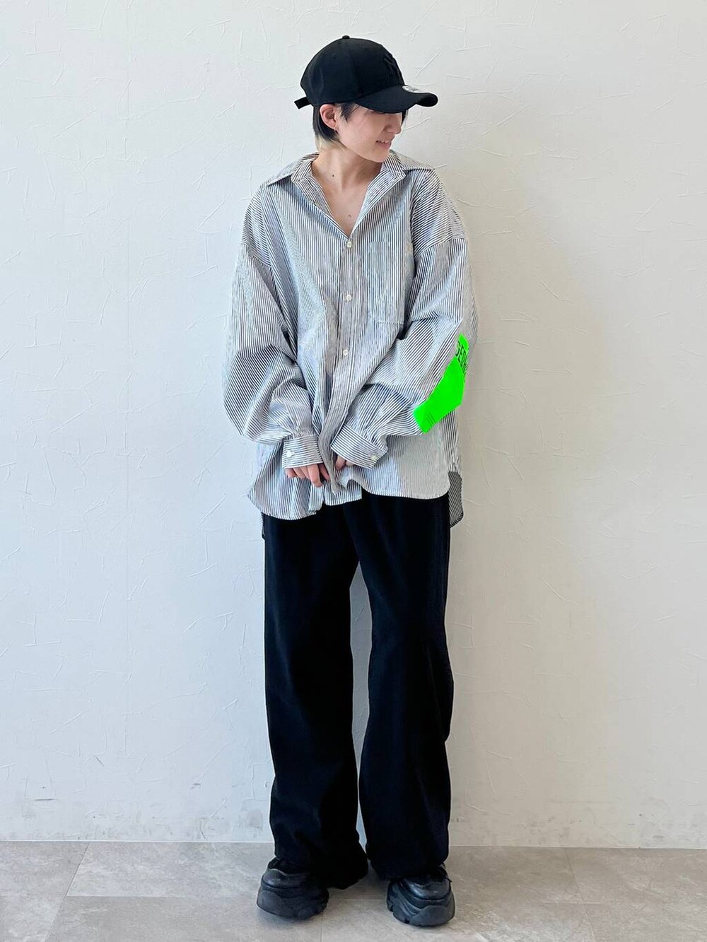 ブラック系のスニーカー、ブラック系のチノパンツ、ブラック系のキャップを着用したレディースの春コーディネートの2枚目の写真