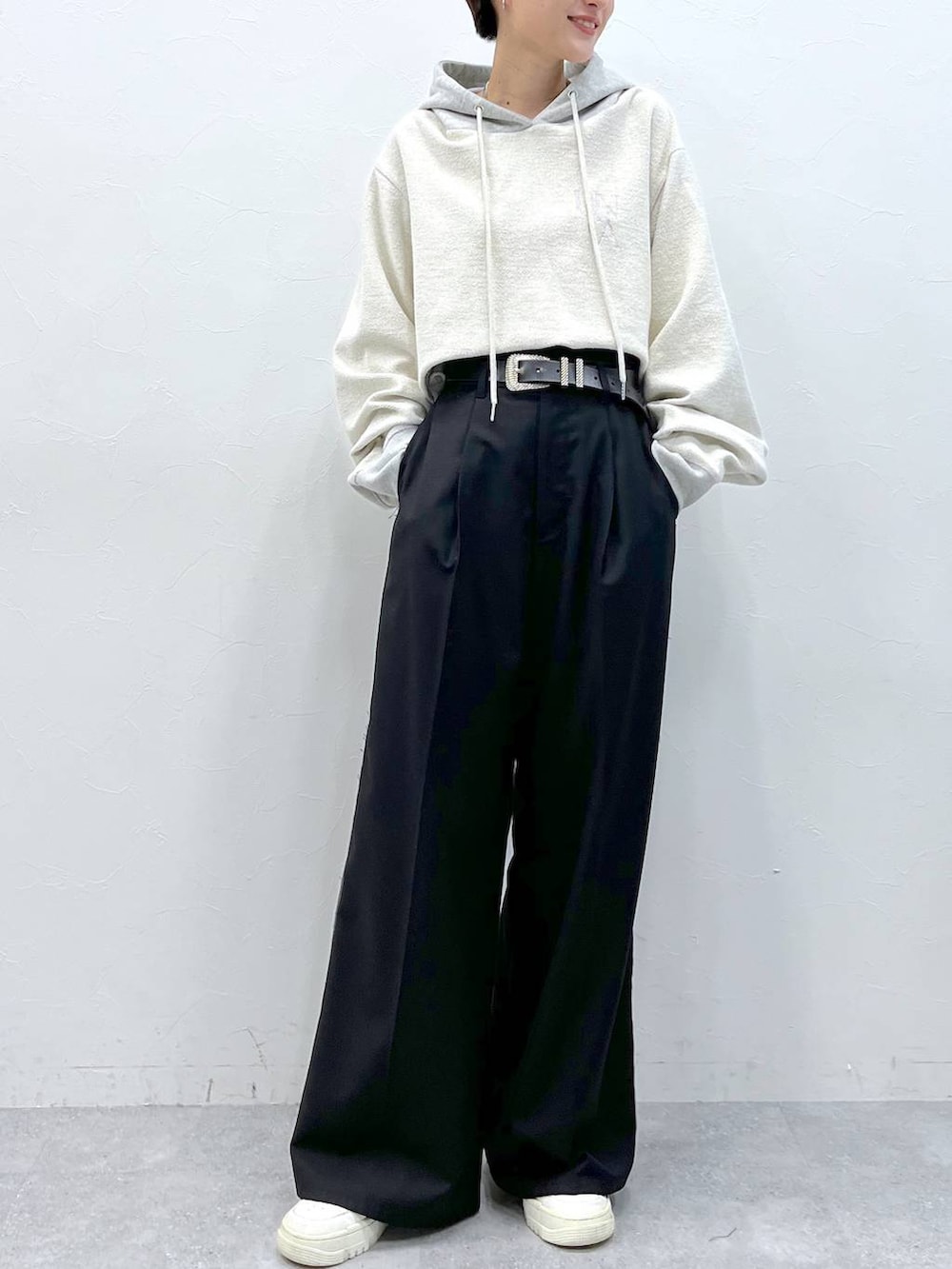 ブラック系のスラックス、グレー系のパーカーを着用したレディースの秋コーディネートの2枚目の写真