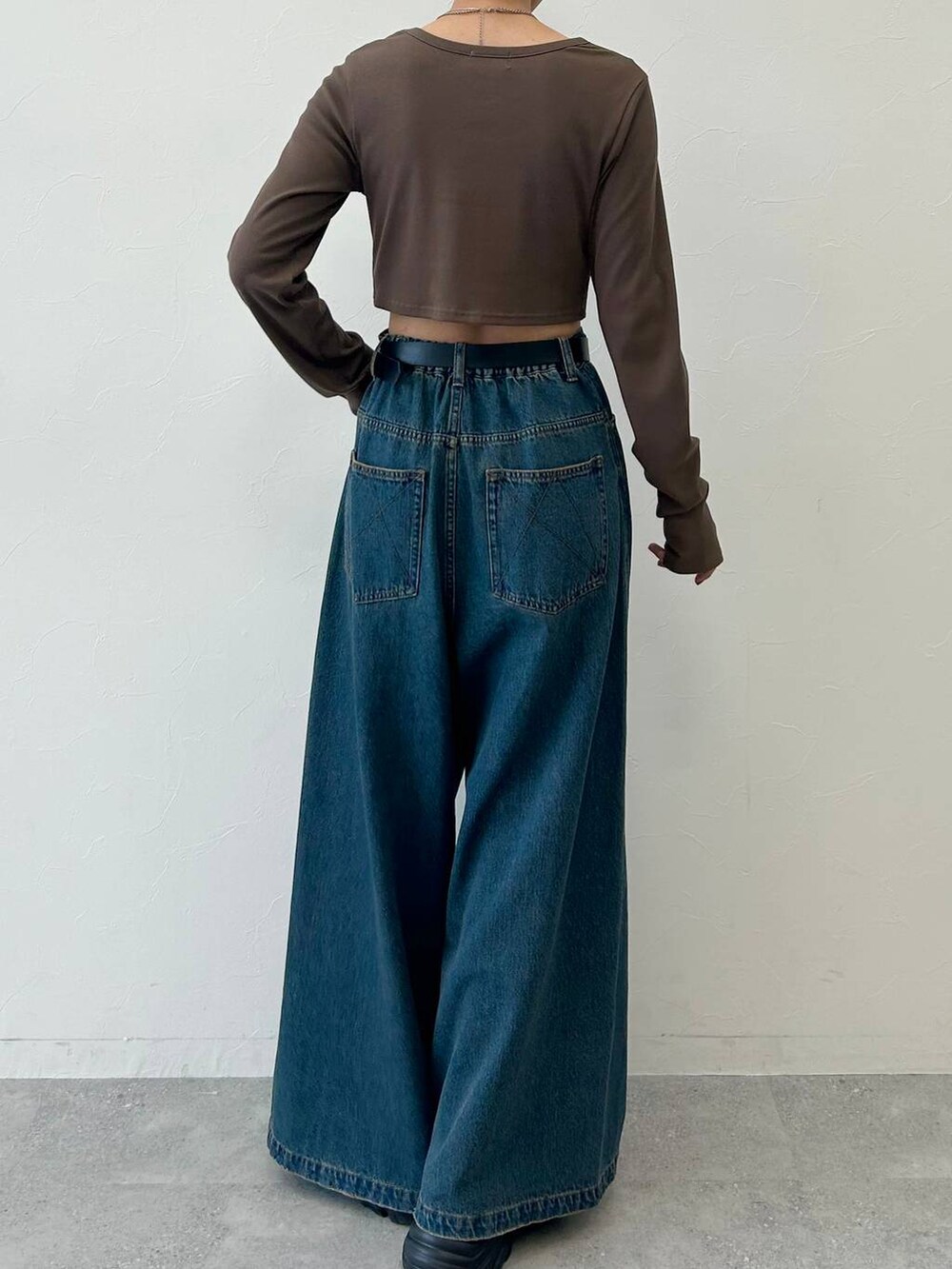 ブラック系のスニーカー、ブルー系のデニムパンツ、ブラウン系のTシャツ/カットソーを着用したレディースの春コーディネートの6枚目の写真