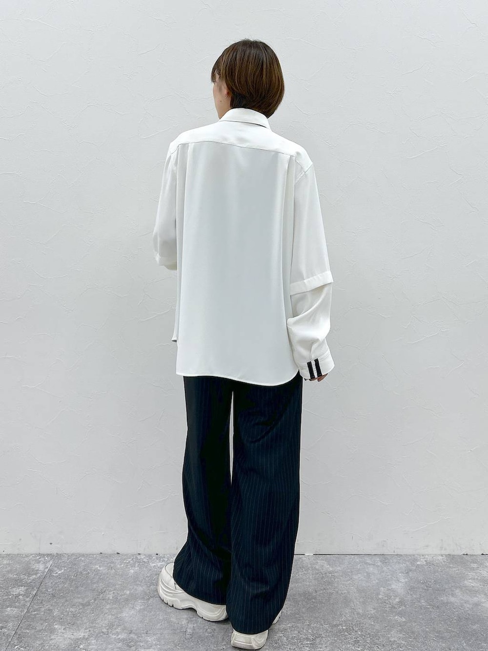 ブラック系のネクタイ、ホワイト系のシャツ/ブラウス、ブラック系のスラックスを着用したレディースの春コーディネートの6枚目の写真