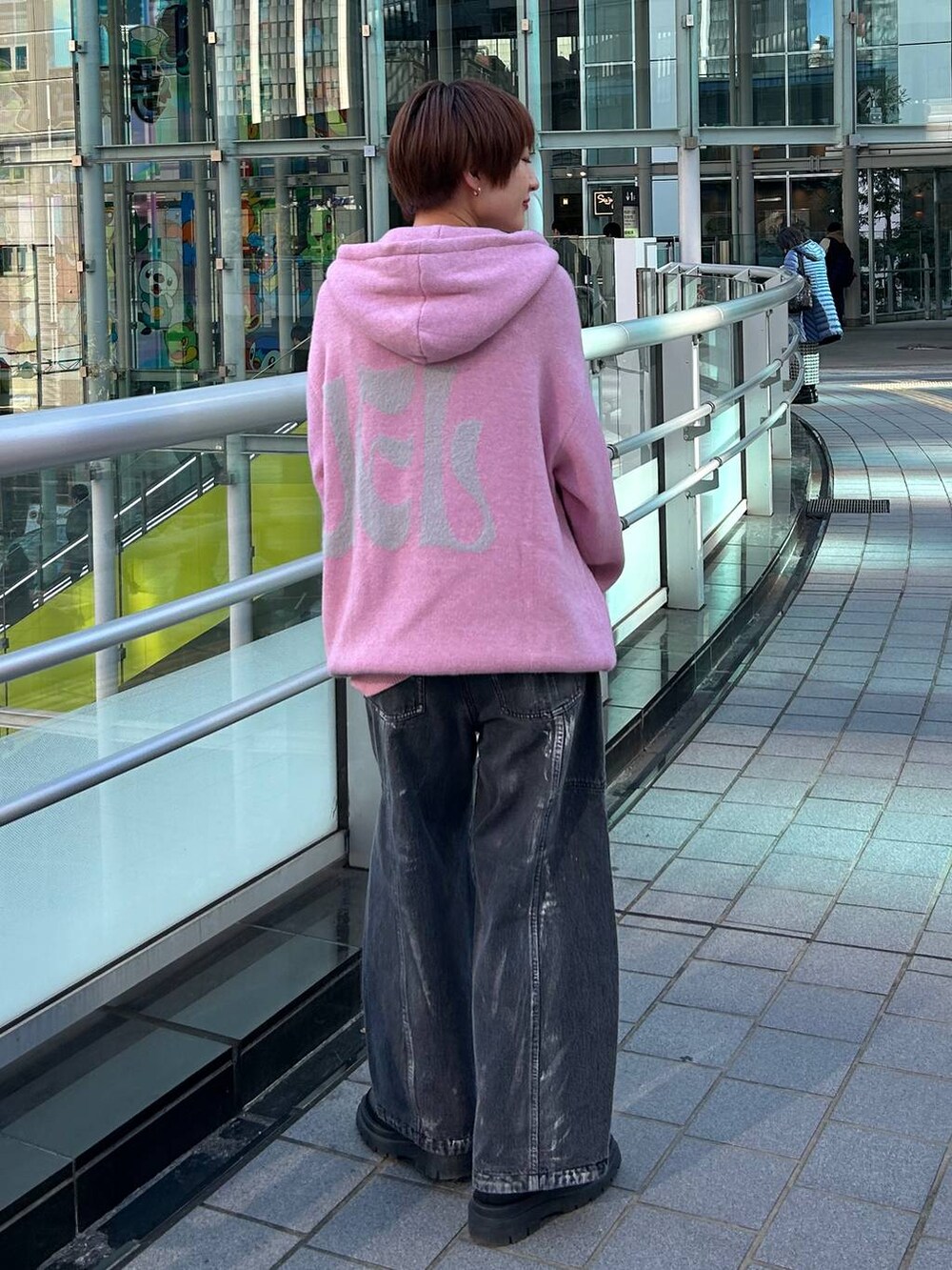 ピンク系のニット/セーター、ブラック系のデニムパンツを着用したレディースの冬コーディネートの7枚目の写真