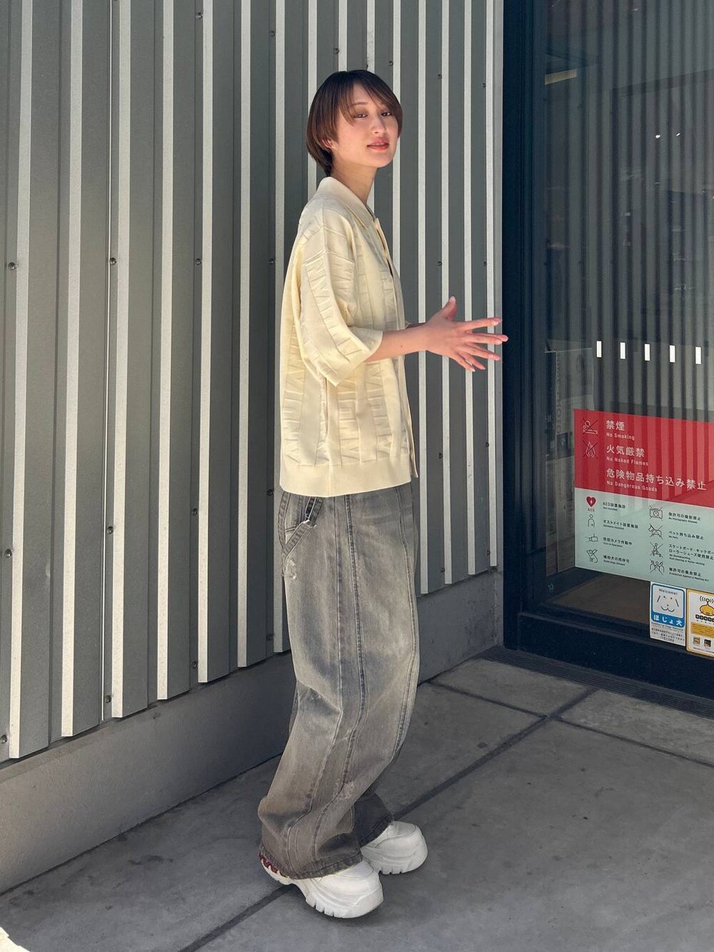 ブラック系のデニムパンツ、ホワイト系のニット/セーターを着用したレディースの春コーディネートの5枚目の写真