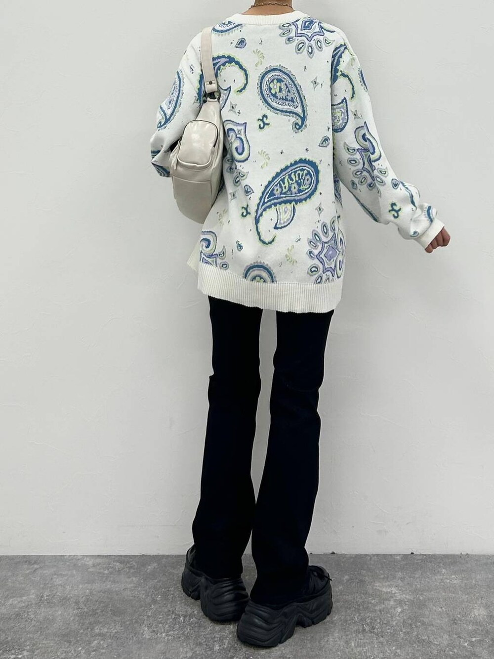 ブラック系のスニーカー、ホワイト系のショルダーバッグ、ブラック系のデニムパンツを着用したレディースの冬コーディネートの8枚目の写真